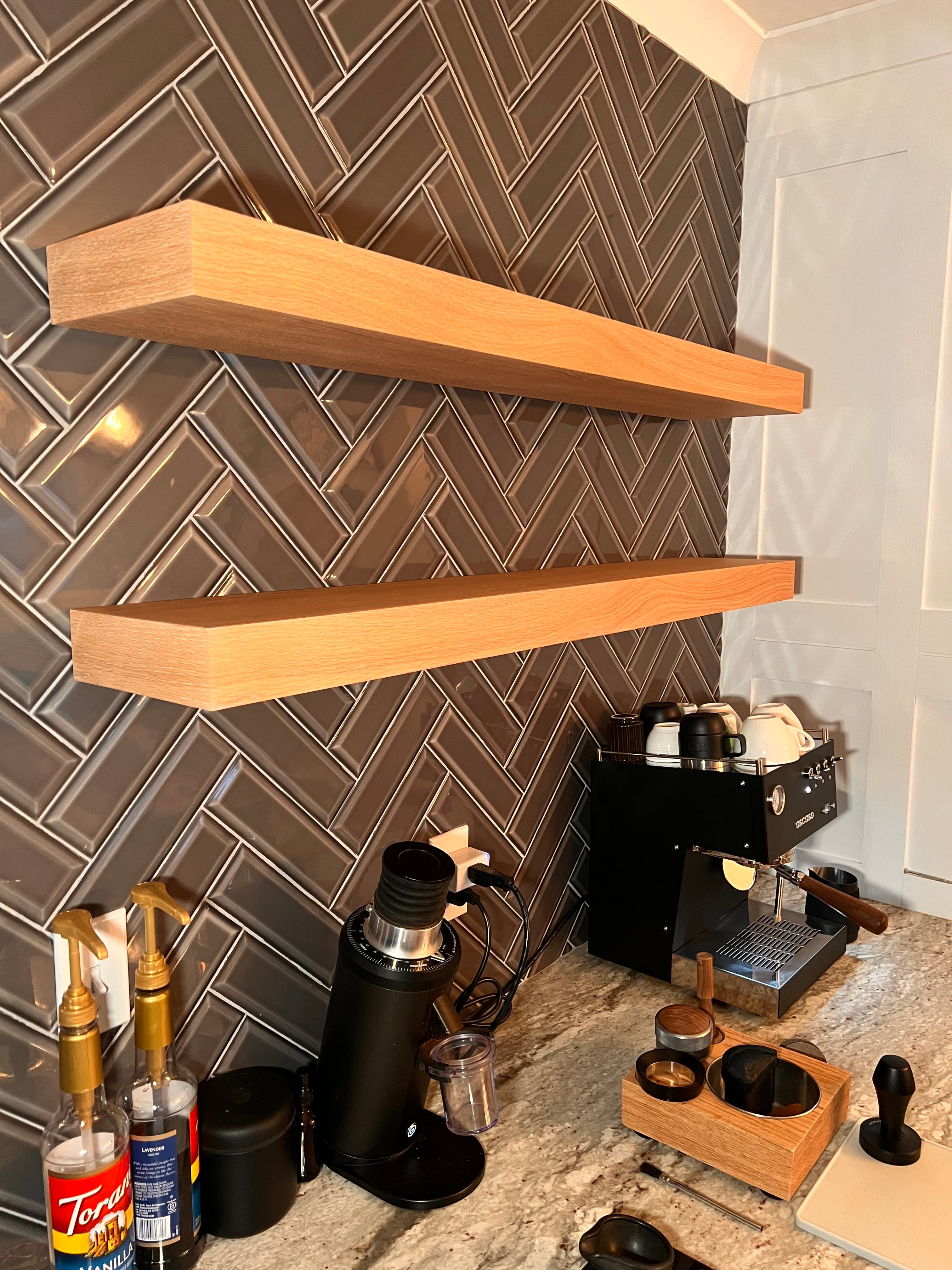 Oak floating shelves installed over a coffee bar